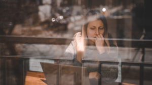 Woman sitting in a coffee shop looking at her laptop